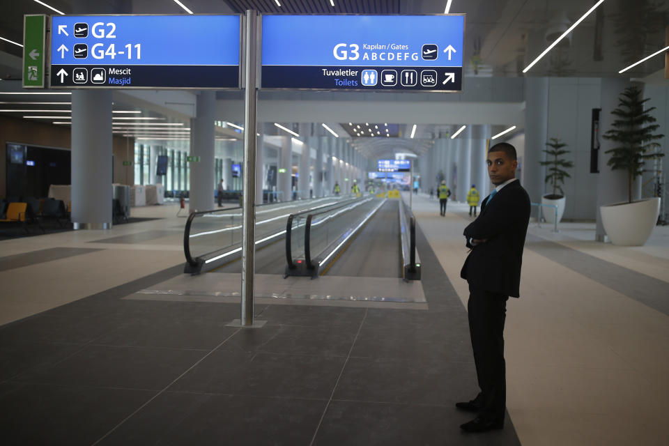 FILE - In this Oct. 25, 2018, file photo, a security guard stands inside a terminal at Istanbul's new airport, ahead of its opening. The first phase of the airport, one of Turkey's President Recep Tayyip Erdogan's major construction projects, is scheduled to be inaugurated on Oct. 29 when Turkey celebrates Republic Day. The massive project, has been mired in controversy over worker's rights and environmental concerns amid a weakening economy. (AP Photo/Emrah Gurel, File)