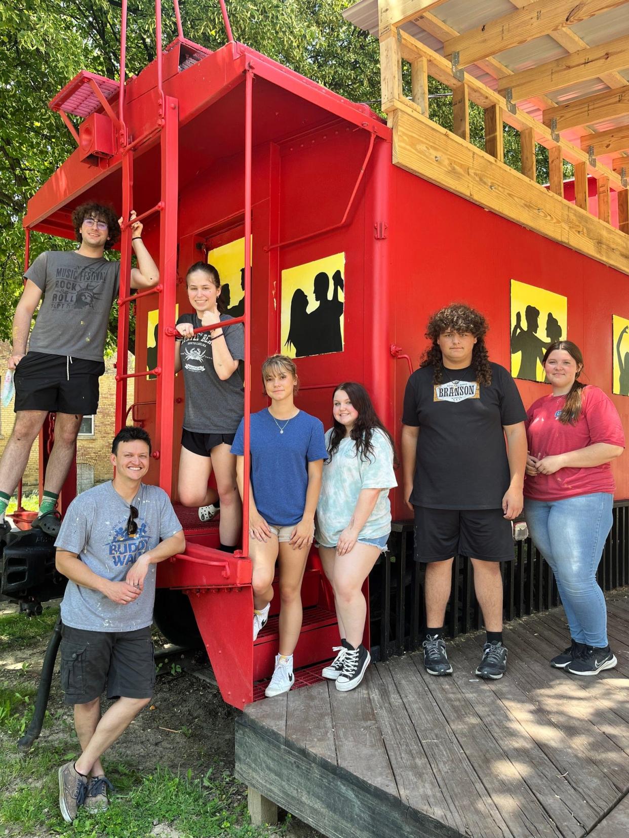 Students in Steve Cabassa's art classes at Alliance High School helped to paint the Downtown Alliance Caboose, giving the structure that's used as a stage for concerts a musically themed design. Cabassa is pictured standing on the grass at the bottom left, and the student artists pictured, from left, are Evan Winans, Eliza McDonald, Mia Pasco, Ally Sherwood, Garrett Adkins and Madyson Kline.