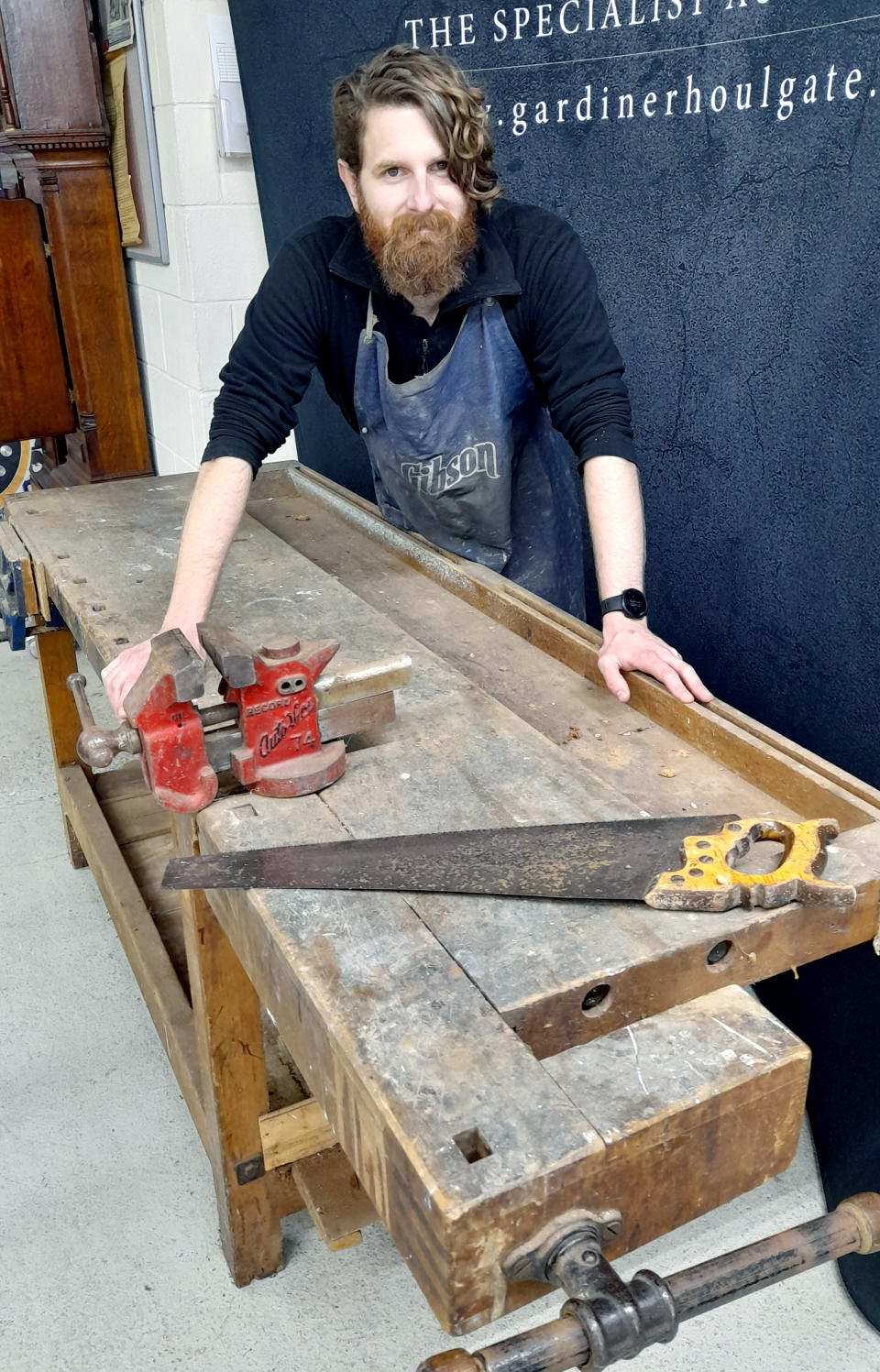 El subastador Luke Hobbs con un banco de trabajo perteneciente al fabricante de guitarras Tony Zemaitis (Gardiner Houlgate/PA)