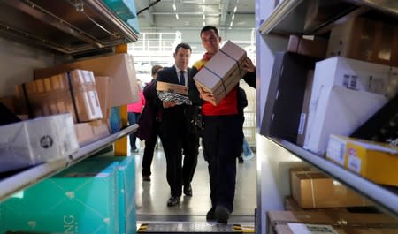 German Labour Minister Hubertus Heil carries a parcel as he visits a German postal and logistics group Deutsche Post DHL parcels distribution centre in Berlin