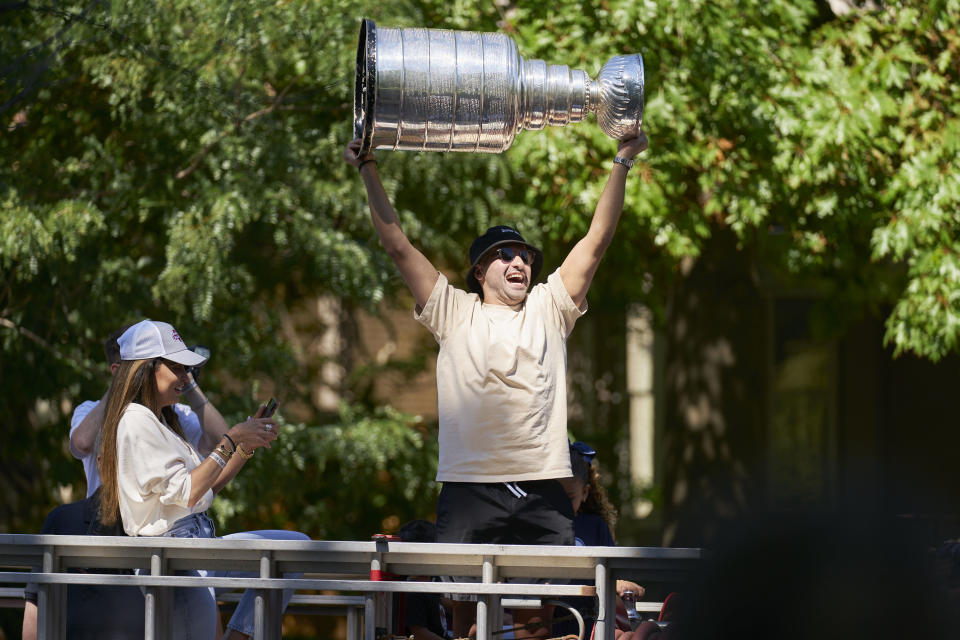 Colorado Avalanche's Nazem Kadri holds the Stanley Cup from atop a fire truck during a parade in London, Ontario on Saturday, Aug. 27, 2022. Kadri, 31, won the cup for the first time while playing with the Colorado Avalanche. (Geoff Robins/The Canadian Press via AP)