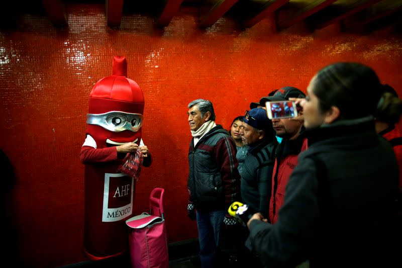 A man wearing a costume, representing a condom, is seen at a metro station giving free condoms on the International Condoms Day, celebrated a day before Valentine Day, in Mexico City