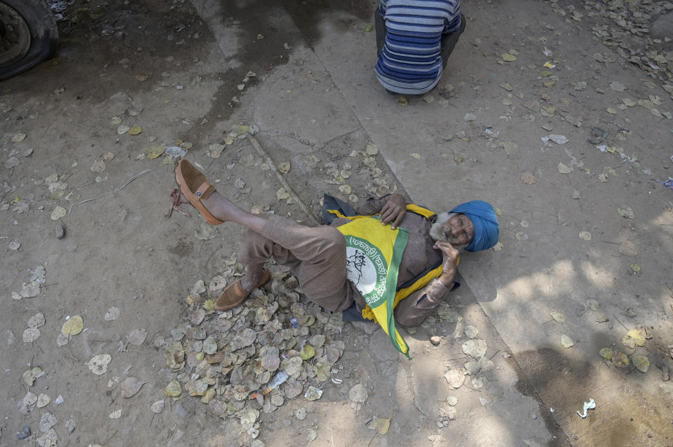 An elderly farmer rests his back lying in the shade as Indian farmers who have been protesting to demand guaranteed crop prices gather at Ramlila ground in New Delhi, India, Thursday, March 14, 2024. (AP Photo)