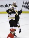 Detroit Red Wings center David Legwand skates by as Boston Bruins defenseman Dougie Hamilton (27) and left wing Milan Lucic celebrate the Bruins' 3-2 overtime win in Game 4 of a first-round NHL hockey playoff series in Detroit, Thursday, April 24, 2014. Jarome Iginla was credited with the goal with an assist by Hamilton. (AP Photo/Carlos Osorio)