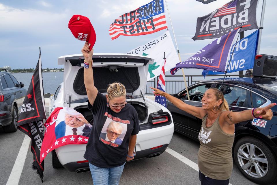 Trump supporters Maria Korynsel, left, and Debbie Macchia dance and sing near Mar-a-Lago on May 30, 2024 in Palm Beach, Florida after former President Donald Trump was found guilty on all counts in his New York criminal hush money trial.