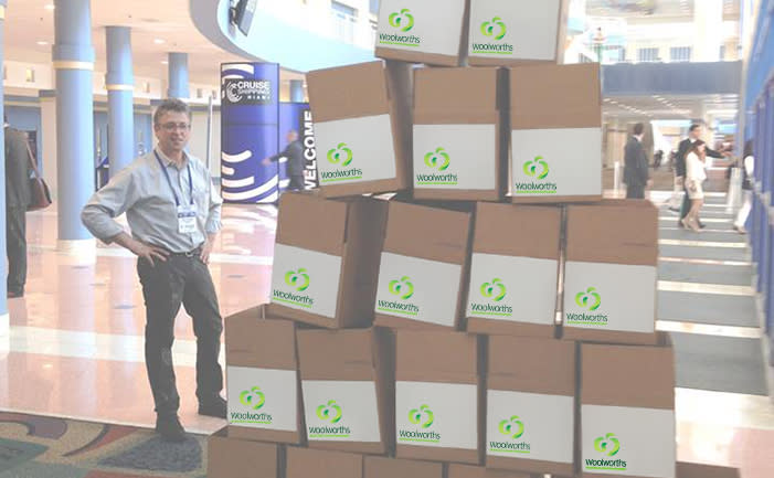 Man with many cardboard boxes piled high with Woolworths logos edited onto them. 