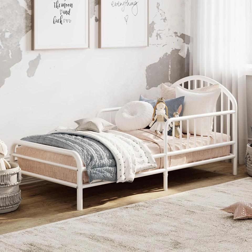 The white, metal frame bed with built-in headboard and footboard
