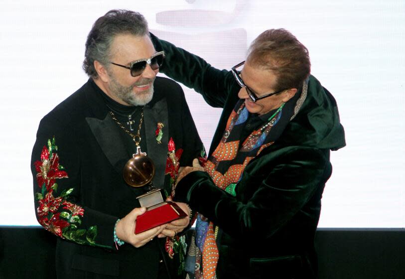 Mexican composer and singer Emmanuel, right, presented fellow Mexican singer Mijares the Lifetime Achievement Award