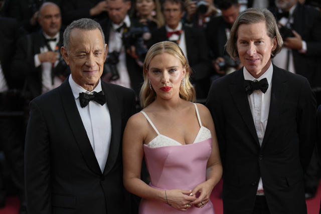Tom Hanks, de izquierda a derecha, Scarlett Johansson y el director Wes Anderson posan al llegar al estreno de la película 'Asteroid City' en la 76a edición del festival internacional de cine de Cannes, en el sur de Francia, el martes 23 de mayo de 2023. (Foto AP/Daniel Cole)
