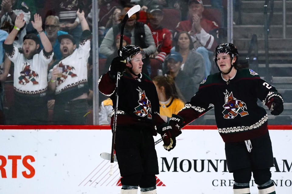 Arizona Coyotes center Travis Boyd, left, celebrates his goal against the Nashville Predators with center Barrett Hayton during the second period of an NHL hockey game Friday, April 29, 2022, in Glendale, Ariz. (AP Photo/Ross D. Franklin)