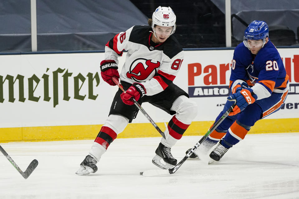 New Jersey Devils' Jack Hughes (86) vies for control of the puck with New York Islanders' Kieffer Bellows (20) during the third period of an NHL hockey game Thursday, Jan. 21, 2021, in Uniondale, N.Y. (AP Photo/Frank Franklin II)