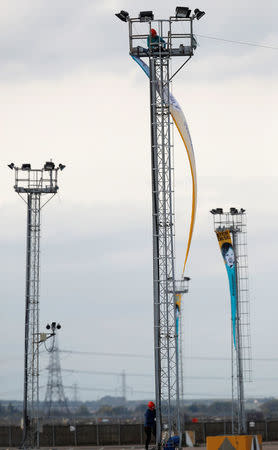 Greenpeace activists unfurl a banner from a lighting tower after activists entered the vehicle park in a protest against Volkswagen diesel vehicles at the port of Sheerness, Britain, September 21, 2017. REUTERS/Peter Nicholls