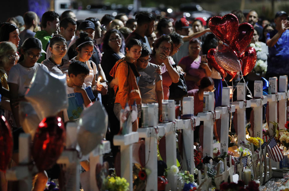 FILE - People crowd around a makeshift memorial near the site of a mass shooting at a shopping complex, on Aug. 5, 2019, in El Paso, Texas. The shooting at a supermarket on Saturday, May 14, 2022, in Buffalo, New York, is the latest example of something that's been part of U.S. history since the beginning: targeted racial violence. For many Black Americans, the Buffalo shooting has stirred up the same feelings they faced after other attacks: the fear, the vulnerability, the worry that nothing will be done politically or otherwise to prevent the next act of targeted racial violence. (AP Photo/John Locher, File)