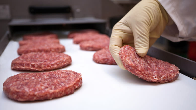 Person arranging ground beef patties