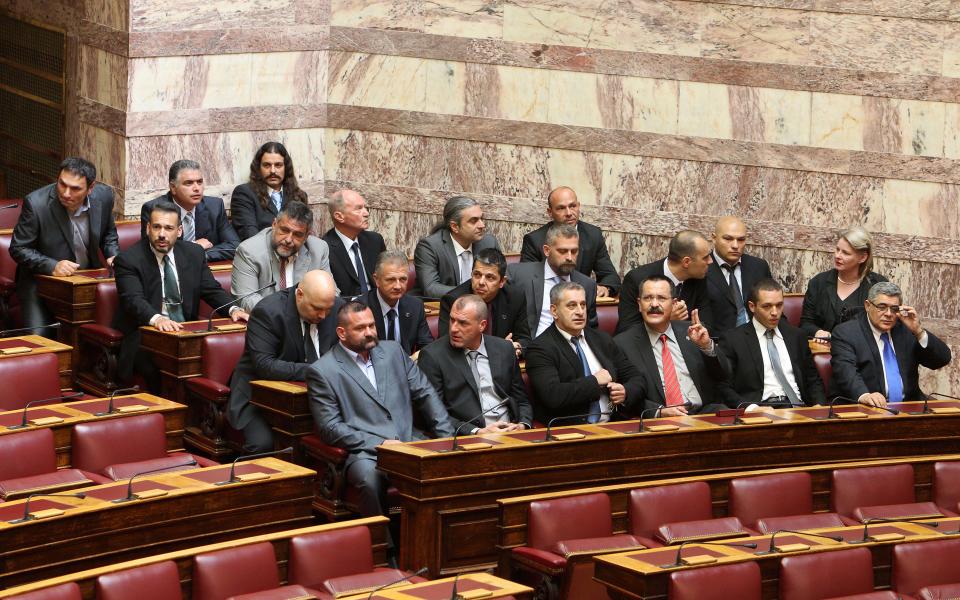 Members of parliament from the extreme right-wing Golden Dawn party, are seated before a swearing in ceremony at the Greek parliament in Athens, Thursday, May 17, 2012. Among the deputies to take their seats for a day are 21 from the Golden Dawn party, which rejects the neo-Nazi label. It campaigned on pledges to rid Greece of immigrants and clean up neighborhoods. (AP Photo/Thanassis Stavrakis)