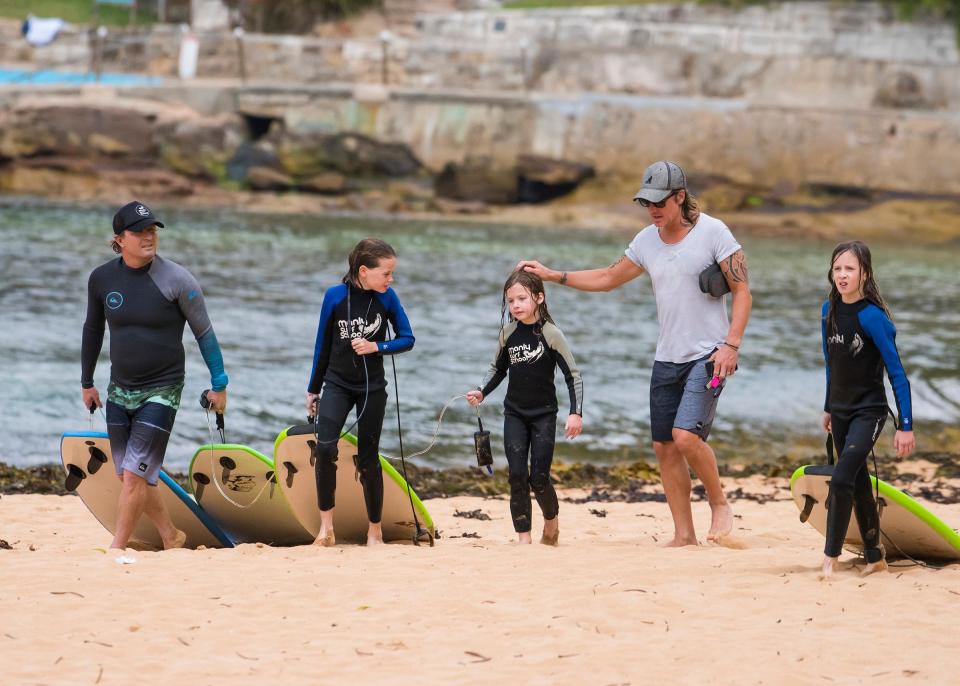 <p>Doting father Keith went to greet the girls at the water's edge with his friend and daughter along with Sunday and Faith who were carrying their surfboards onto the sand.</p>