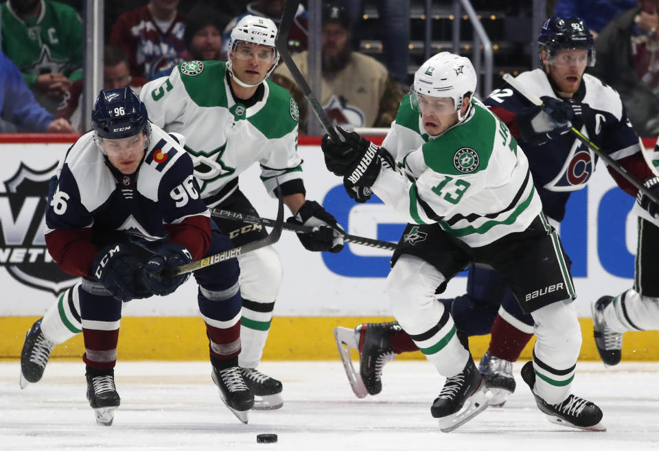 Colorado Avalanche right wing Mikko Rantanen, left, and Dallas Stars center Mattias Janmark, right, pursue the puck as defenseman Andrej Sekera trails the play in the second period of an NHL hockey game Tuesday, Jan. 14, 2020, in Denver. (AP Photo/David Zalubowski)