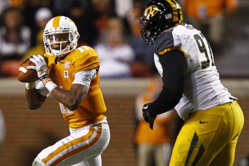 Tennessee quarterback Joshua Dobbs (11) looks for a receiver as he's pressured by Missouri defensive lineman Josh Augusta (97) in the second half of an NCAA college football game Saturday, Nov. 22, 2014 in Knoxville, Tenn. Missouri won 29-21. (AP Photo/Wade Payne)