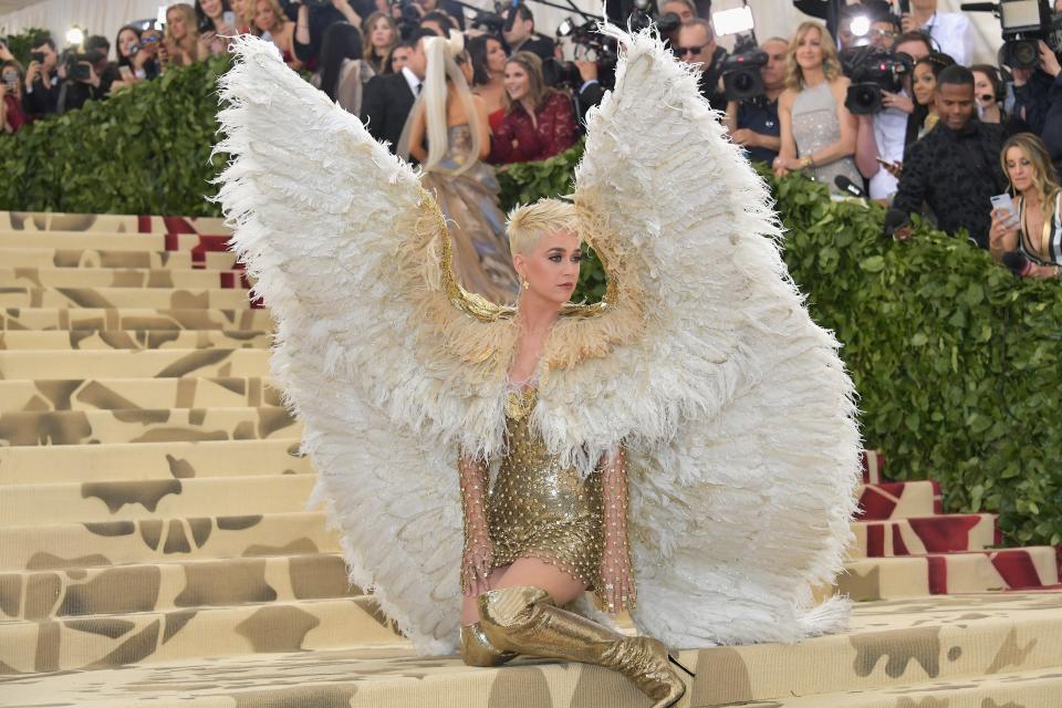 At the 2018 Met Gala, Katy Perry wore feathered angel wings that reached well above her head down to the floor with a gold dress and thigh-high boots.