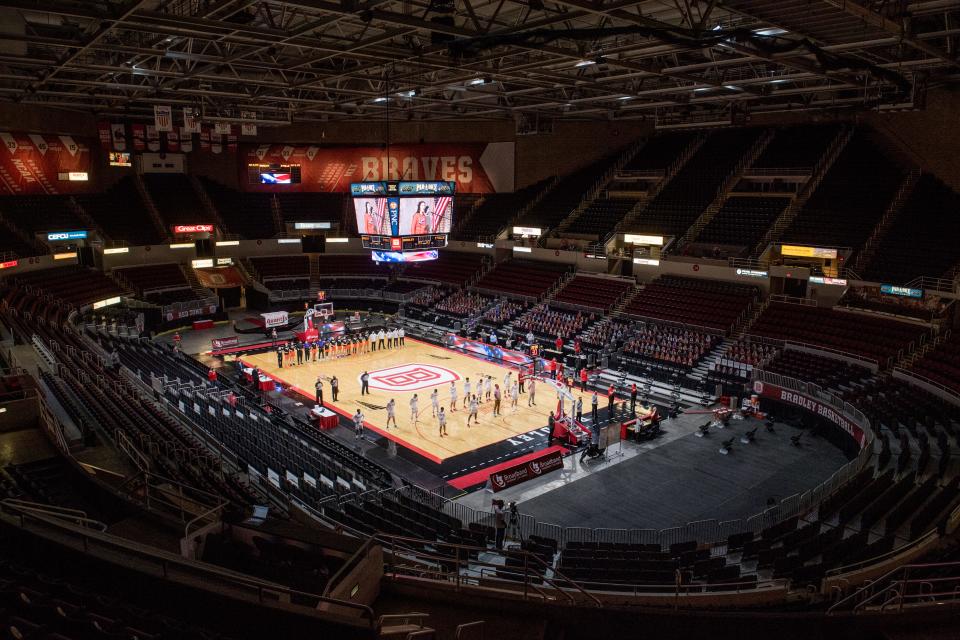 Basketball players stand for the national anthem in an empty Carver Arena before a recent Bradley men’s basketball game at the Peoria Civic Center.