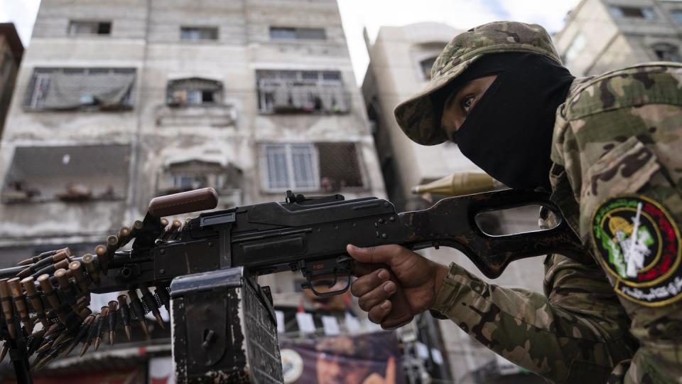 A Hamas militant holds a squad automatic weapon perched atop a truck during a parade through the streets for Bassem Issa, a top Hamas' commander, who was killed by Israeli Defense Force military actions prior to a cease-fire reached after an 11-day war between Gaza's Hamas rulers and Israel, in Gaza City, May 22, 2021. (John Minchillo/The Associated Press)