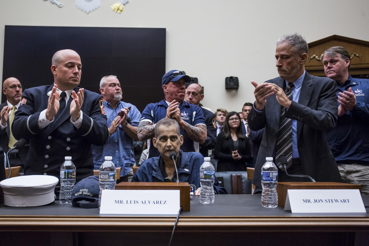 Jon Stewart, right, applauds following testimony from retired NYPD detective and 9/11 first responder Luis Alvarez during a House Judiciary Committee hearing last week on Capitol Hill.  (Photo by Zach Gibson/Getty Images)