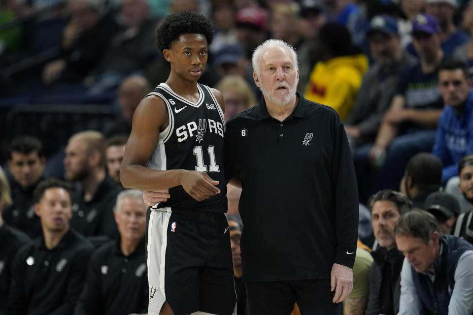 San Antonio Spurs guard Joshua Primo (11) and head coach Gregg Popovich watch play during the first half of an NBA basketball game against the Minnesota Timberwolves, Monday, Oct. 24, 2022, in Minneapolis. (AP Photo/Abbie Parr)