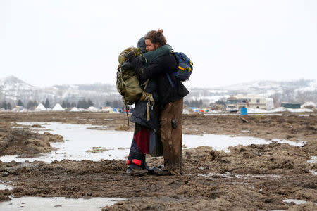 Susanna Travis (left), from Grass Valley, California, embraces Timothy Powers, also from California, before evacuating the main opposition camp against the Dakota Access oil pipeline near Cannon Ball, North Dakota. REUTERS/Terray Sylvester