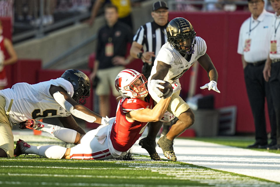 Wisconsin's Haakon Anderson (27) tackles Purdue wide receiver Deion Burks (4) during the second half of an NCAA college football game Saturday, Oct. 22, 2022, in Madison, Wis. Wisconsin won 35-24. (AP Photo/Andy Manis)