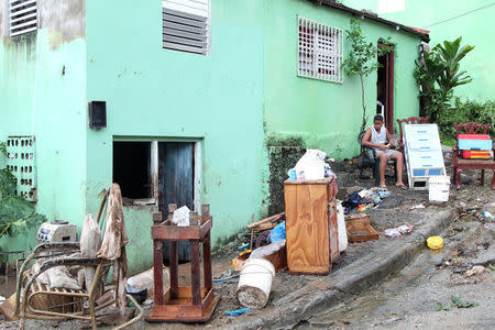 A child sits in front of a house affected by the overflow of the Soco River in the aftermath of Hurricane Maria in El Seibo, Dominican Republic, September 22, 2017. REUTERS/Ricardo Rojas