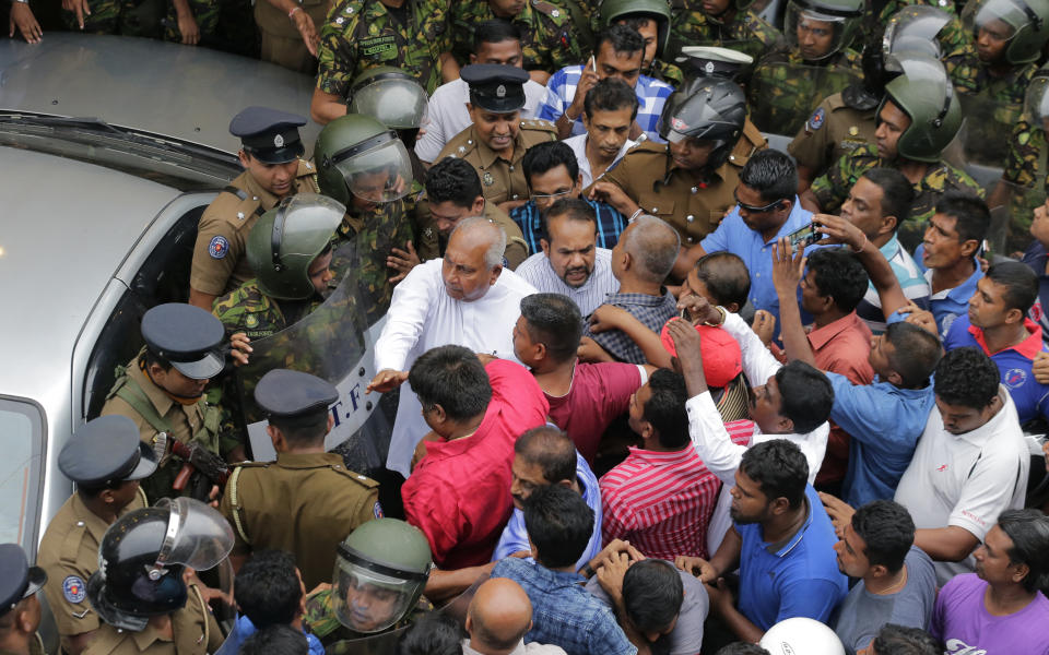 Sri Lankan security forces are deployed near the petroleum ministry building in Colombo, Sri Lanka, Sunday, Oct. 28, 2018. Arjuna Ranatunga who was petroleum minister under Wickremesinghe said one of his security guards opened fire when Rajapaksa supporters mobbed him and protested against him entering the ministry premises. (AP Photo/Eranga Jayawardena)