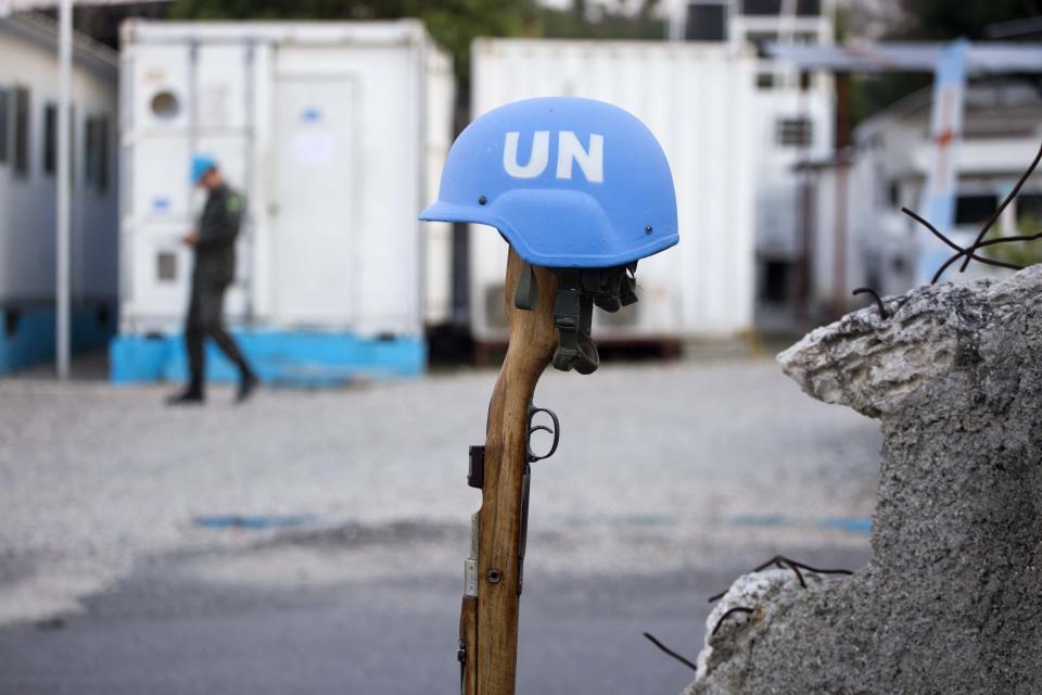 This Feb. 22, 2017 photo shows a U.N. peacekeeper's blue helmet balanced on a weapon in Port-au-Prince, Haiti. "We have a secure and stable environment," said Col. Luis Antonio Ferreira Marques Ramos, deputy commander of the Brazilian peacekeeper contingent in Haiti. "The important thing is to leave in a good way." (AP Photo/Dieu Nalio Chery)