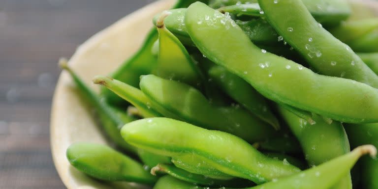 bowl of edamame beans on bamboo mat