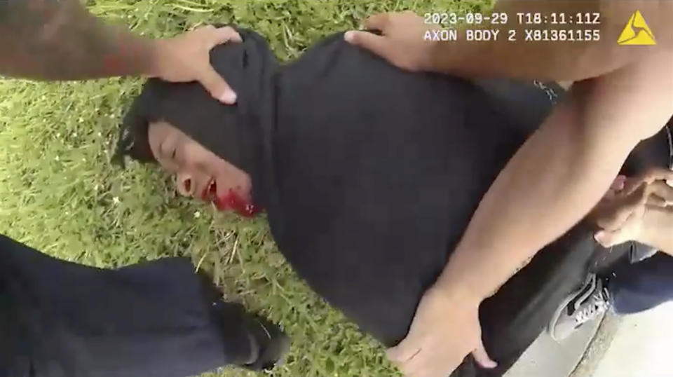 In this image taken from Jacksonville (Florida) Sheriff's Office body camera video, suspect Le'Keian Woods lies on the ground after being beaten and shot with a Taser stun gun during his arrest, Friday, Sept. 29, 2023, in Fla. A Florida sheriff released the body camera video Monday, Oct. 2, that he says shows his officers were justified when they repeatedly punched, elbowed and kneed Woods, a drug suspect, who gave chase after being pulled over with two others during a traffic stop. (Jacksonville Sheriff's Office via AP)