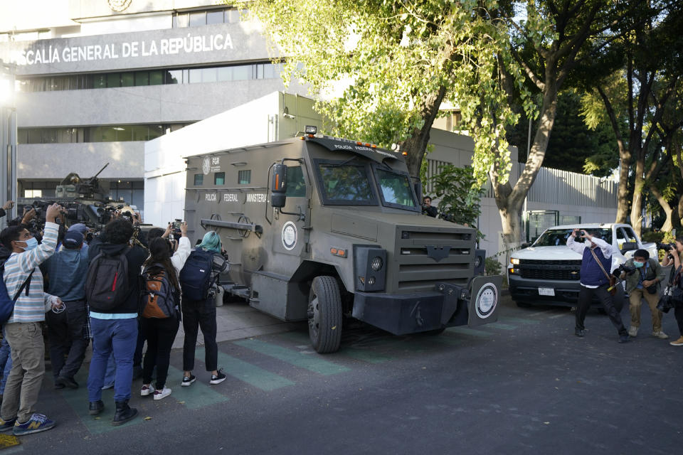 Members of the media make images as an armored transport drives out of the prosecutor's building where Ovidio Guzmán, one of the sons of former Sinaloa cartel boss Joaquin "El Chapo" Guzmán, is in custody in Mexico City, Thursday, Jan. 5, 2023. The Mexican military has captured Ovidio Guzman during a operation outside Culiacan, a stronghold of the Sinaloa drug cartel in western Mexico. (AP Photo/Fernando Llano)