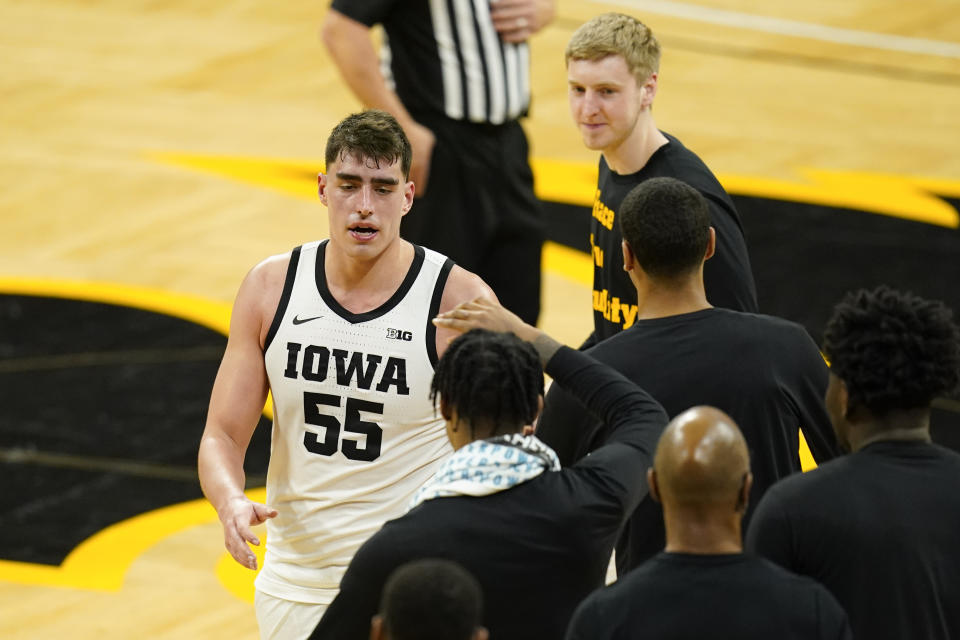 Iowa center Luka Garza (55) celebrates with teammates after scoring a basket and becoming Iowa's all-time leading scorer during the second half of an NCAA college basketball game against Penn State, Sunday, Feb. 21, 2021, in Iowa City, Iowa. (AP Photo/Charlie Neibergall)