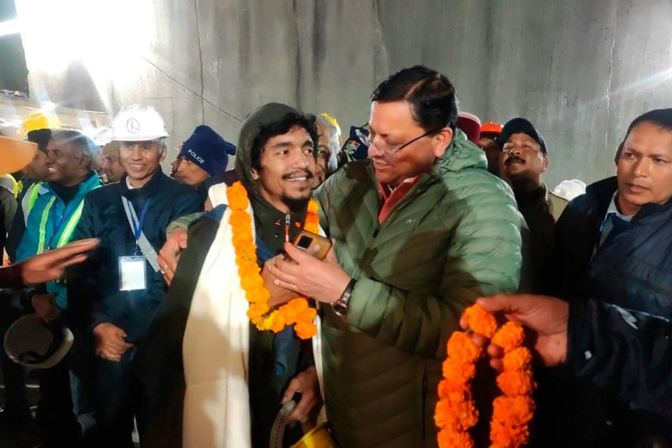 Pushkar Singh Dhami greets a worker rescued from the site of an under-construction road tunnel that collapsed (AP)