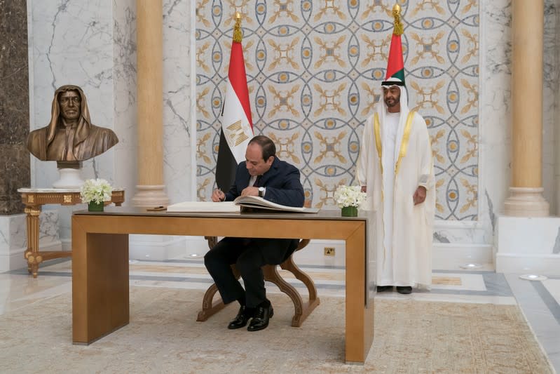 Abu Dhabi's Crown Prince Sheikh Mohammed bin Zayed al-Nahyan stands as Egyptian President Abdel Fattah al-Sisi signs the guest book in Abu Dhabi