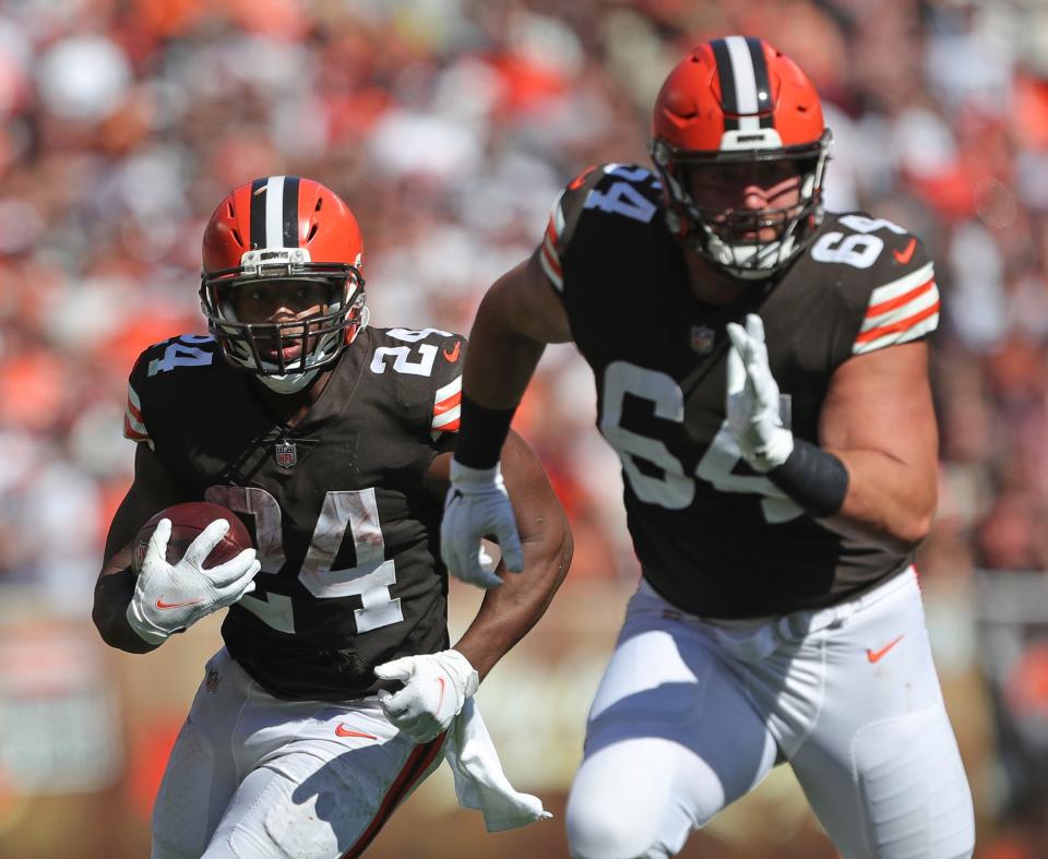 Cleveland Browns running back Nick Chubb (24) rushes for yards behind Cleveland Browns center JC Tretter (64) during the second half of an NFL football game against the Houston Texans, Sunday, Sept. 19, 2021, in Cleveland, Ohio.