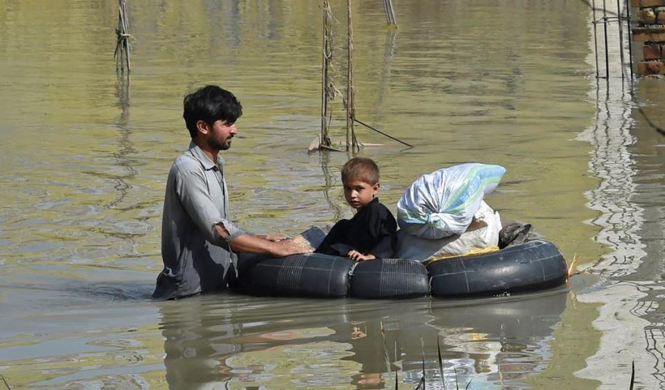 A man pushes his child through a flooded area after heavy monsoon rains  in Charsadda district of Khyber Pakhtunkhwa province, Pakistan, August 29, 2022. / Credit: ABDUL MAJEED/AFP/Getty