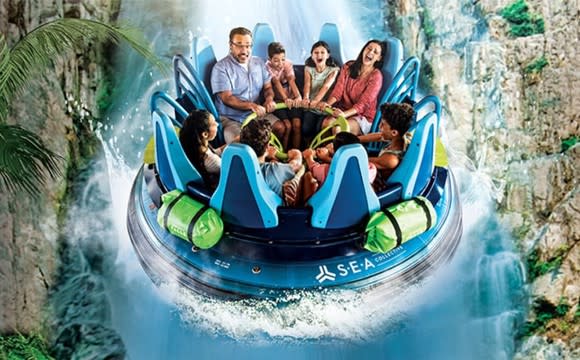 A family of eight in a round water raft going down a waterfall at SeaWorld.