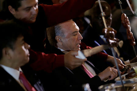 Brazil's President Michel Temer eats barbecue in a steak house after a meeting with ambassadors of meat importing countries of Brazil, in Brasilia, Brazil March 19, 2017. REUTERS/Ueslei Marcelino