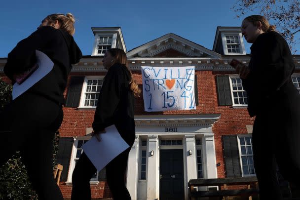 PHOTO: Students walk past a fraternity house with a banner memorializing three University of Virginia football players killed during an overnight shooting at the university, Nov. 14, 2022, in Charlottesville, Va. (Win McNamee/Getty Images)