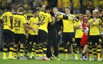 Borussia Dortmund's coach Thomas Tuchel (C) hugs Pierre-Emerick Aubameyang as he celebrates with the rest of the players after winning their Bundesliga first division soccer match against Borussia Moenchengladbach in Gelsenkirchen, Germany August 15, 2015. REUTERS/Ina Fassbender