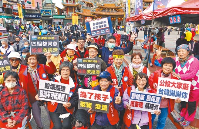 國民黨4日在北市松山慈祐宮前廣場舉辦公投宣講活動，參與的民眾高舉「為了孩子，萊豬滾蛋」等標語，力挺四大公投案。（姚志平攝）