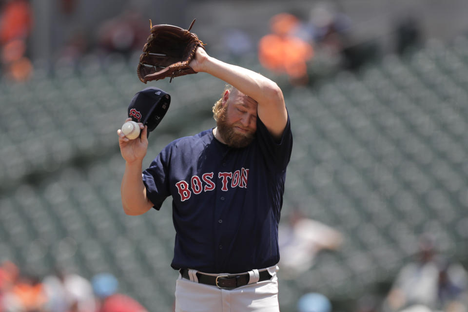 Boston Red Sox starting pitcher Andrew Cashner wipes his forehead after allowing a home run to Baltimore Orioles' Trey Mancini in the first inning of a baseball game, Sunday, July 21, 2019, in Baltimore. The National Weather Service says the "oppressive and dangerous" heat wave will abate by Monday and Tuesday. The agency says a swath of the East Coast, from the Carolinas up to Maine, faces the greatest heat threat Sunday. (AP Photo/Julio Cortez)