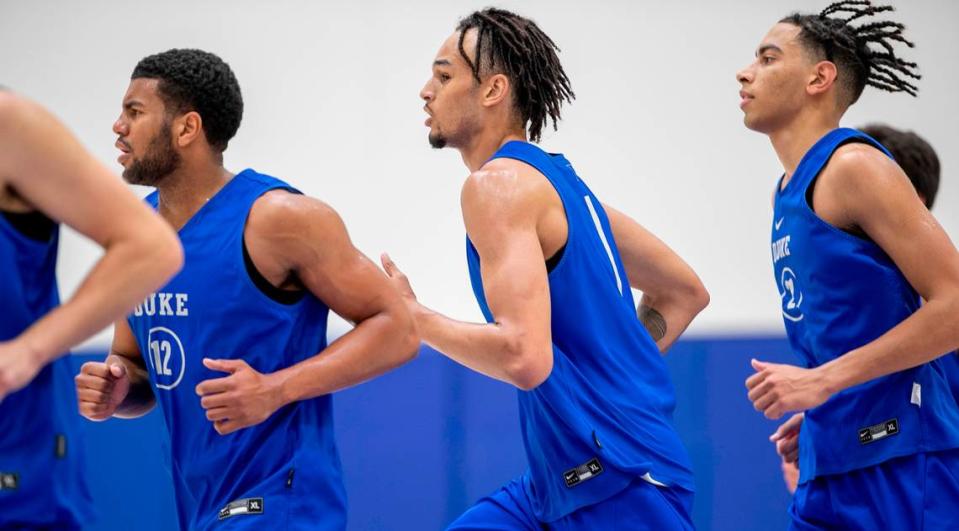 Duke freshmen Kale Catchings (12), Dereck Lively II (1) and Christian Reeves (21) warm up for the Blue Devils’ second practice of the season on Tuesday, September 27, 2022 in Durham, N.C.