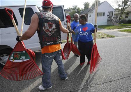 Mayor Karen Freeman-Wilson (R) receives assistance from a volunteer in a neighborhood clean-up project in Gary, Indiana, September 28, 2013. REUTERS/Jim Young