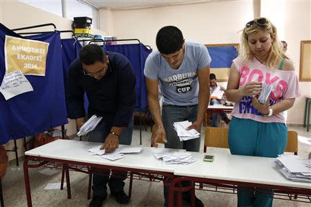 Members of an electoral commission sort ballots into stacks before counting them after the end of voting at a polling station in Hellenikon, a southern suburb of Athens May 18, 2014. REUTERS/Yorgos Karahalis