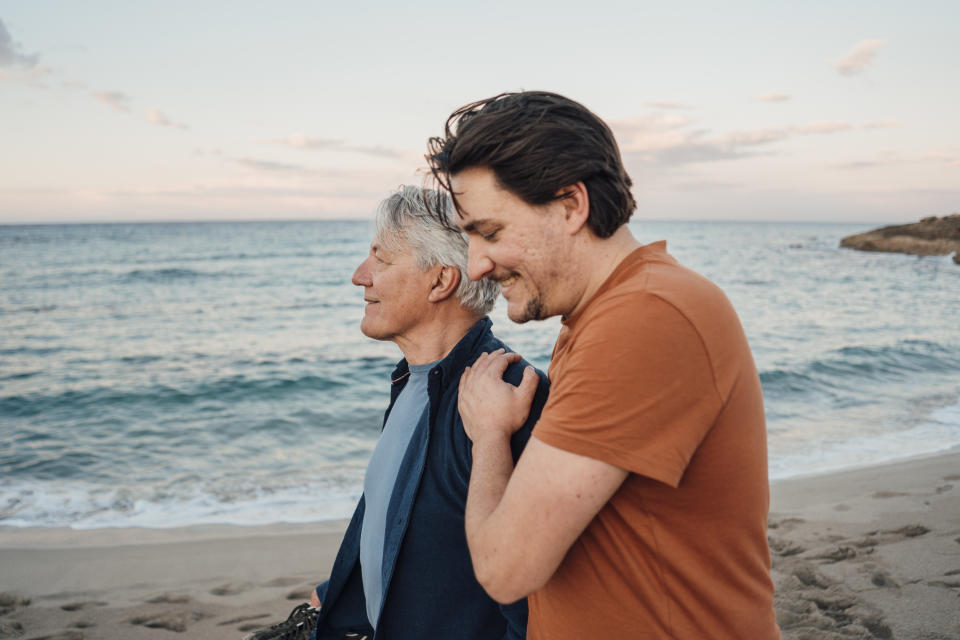 A man walking along the beach with his father